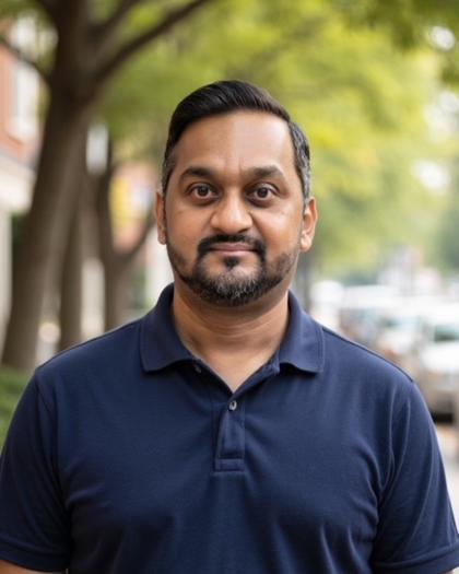 Raj in a navy polo shirt on a tree-lined residential street